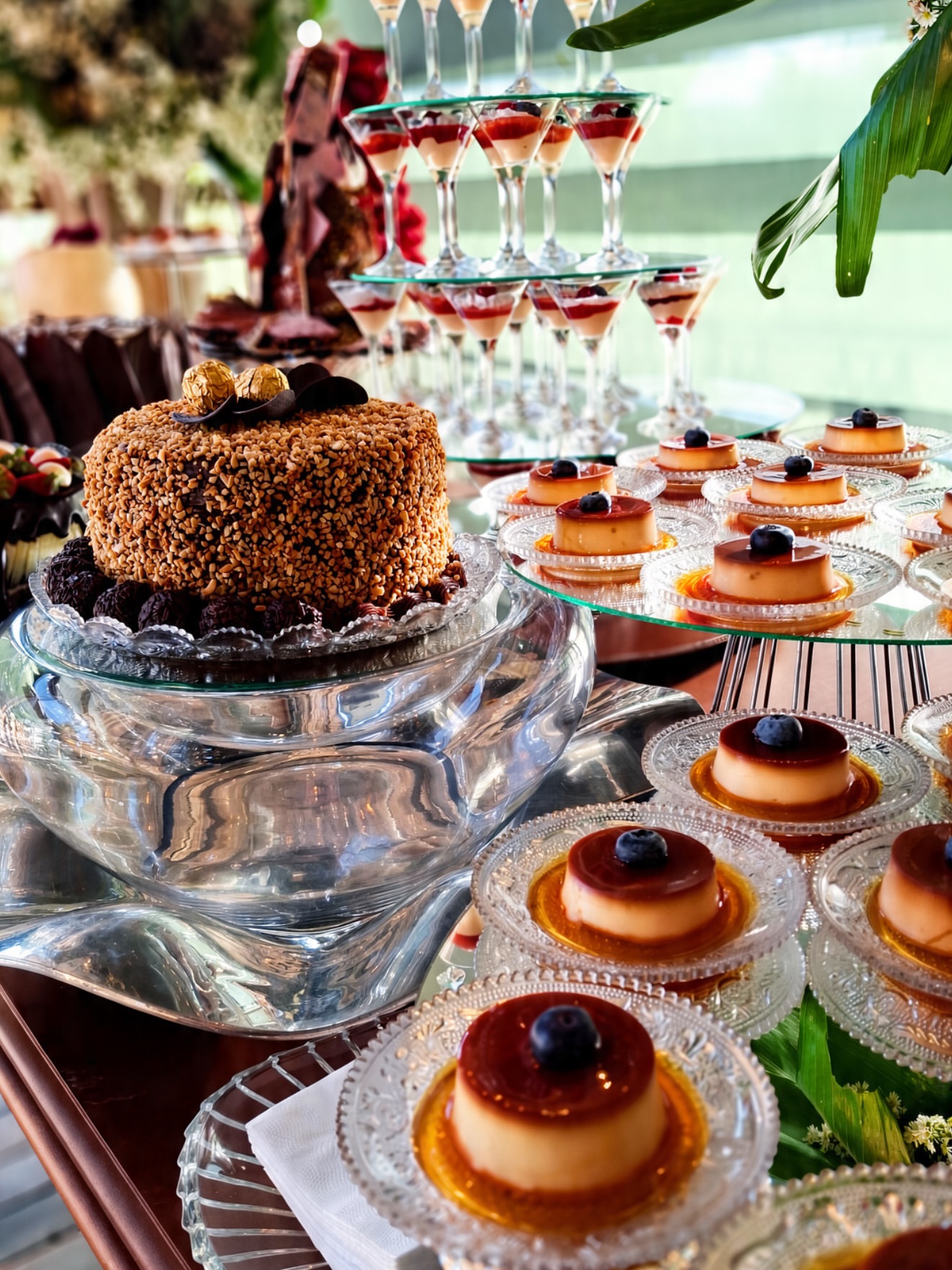 Mesa de doces do casamento de Stefane e Guilherme, com pudins, bolo e taças