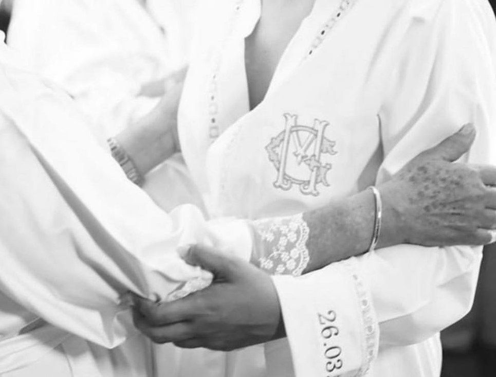 Detalhe das mãos e do vestido bordado da noiva