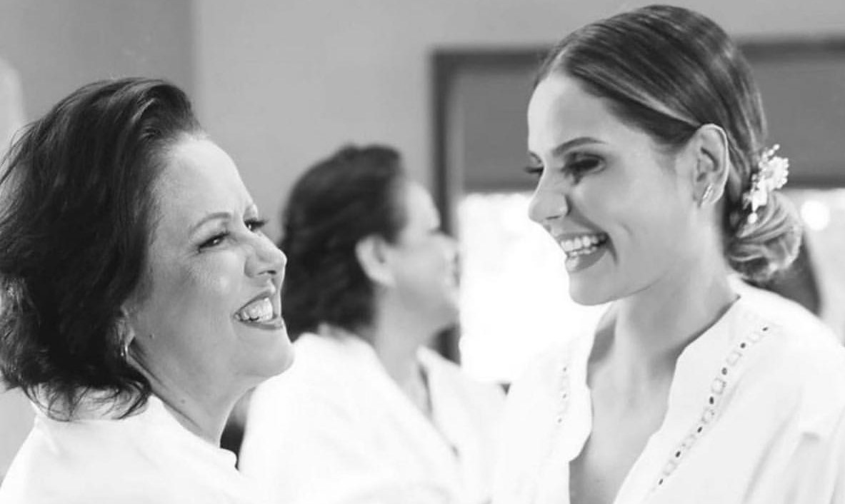 Noiva e mãe sorrindo nos preparativos